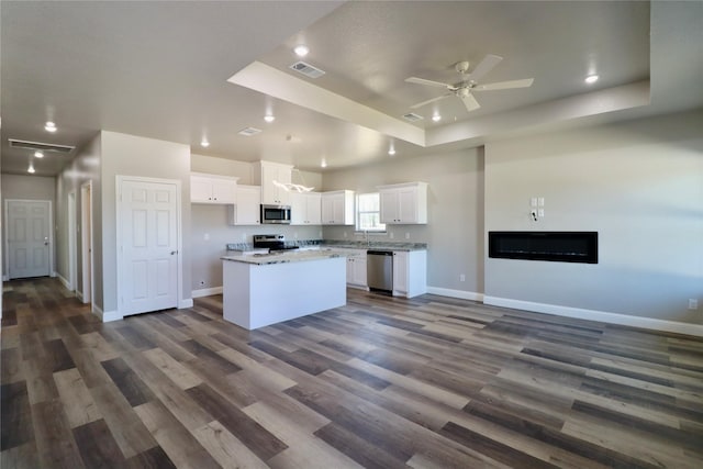 kitchen with visible vents, white cabinets, appliances with stainless steel finishes, and open floor plan