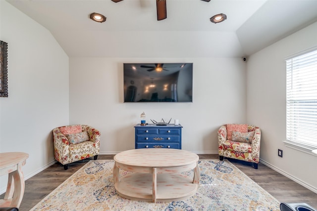 living area with ceiling fan, wood finished floors, and vaulted ceiling