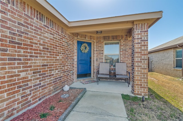 entrance to property featuring brick siding