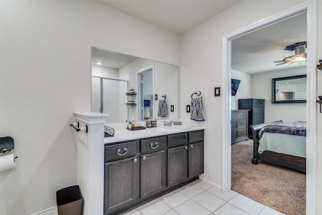 bathroom featuring tile patterned floors, a stall shower, ensuite bathroom, baseboards, and vanity