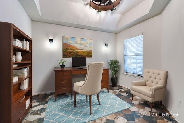 office area featuring a tray ceiling and baseboards