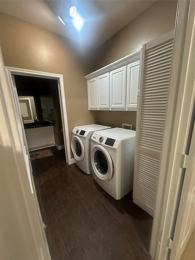 washroom featuring cabinet space, independent washer and dryer, and dark wood-style flooring