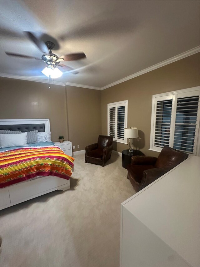 carpeted bedroom featuring baseboards, ornamental molding, and a ceiling fan