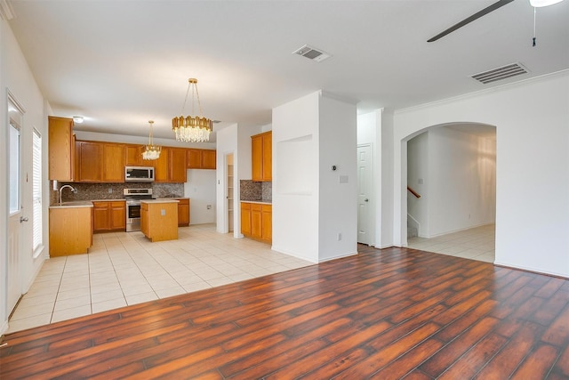 kitchen featuring a sink, visible vents, appliances with stainless steel finishes, and brown cabinets