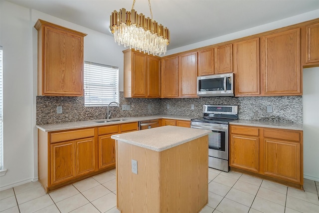 kitchen featuring a sink, a kitchen island, appliances with stainless steel finishes, light countertops, and a chandelier