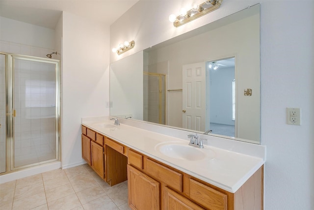 bathroom featuring a sink, double vanity, a stall shower, and tile patterned floors