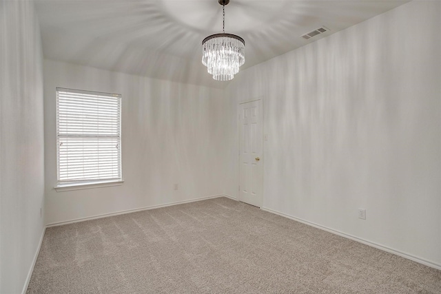 empty room featuring a chandelier, carpet flooring, baseboards, and visible vents