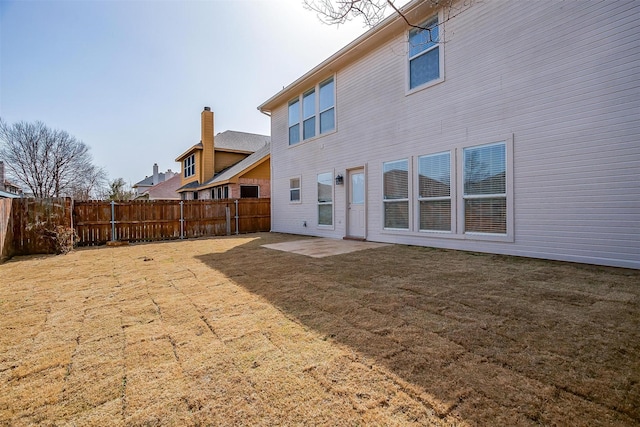 rear view of house featuring a yard, fence private yard, and a patio area