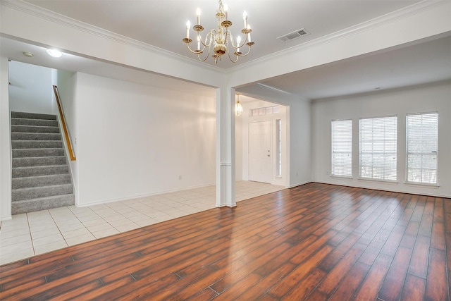 unfurnished living room featuring visible vents, crown molding, stairs, and wood finished floors