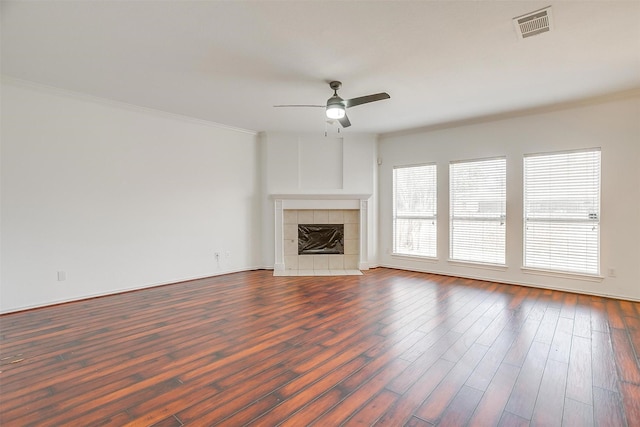 unfurnished living room with visible vents, dark wood-style floors, a fireplace, and ornamental molding