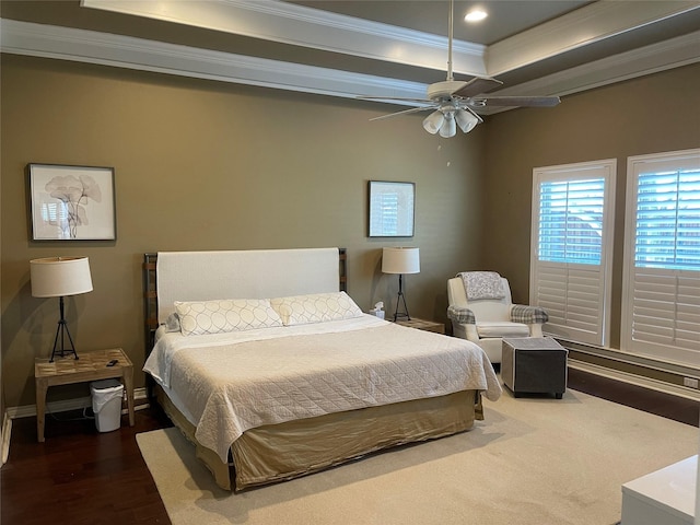 bedroom with baseboards, recessed lighting, dark wood-style flooring, ornamental molding, and a raised ceiling