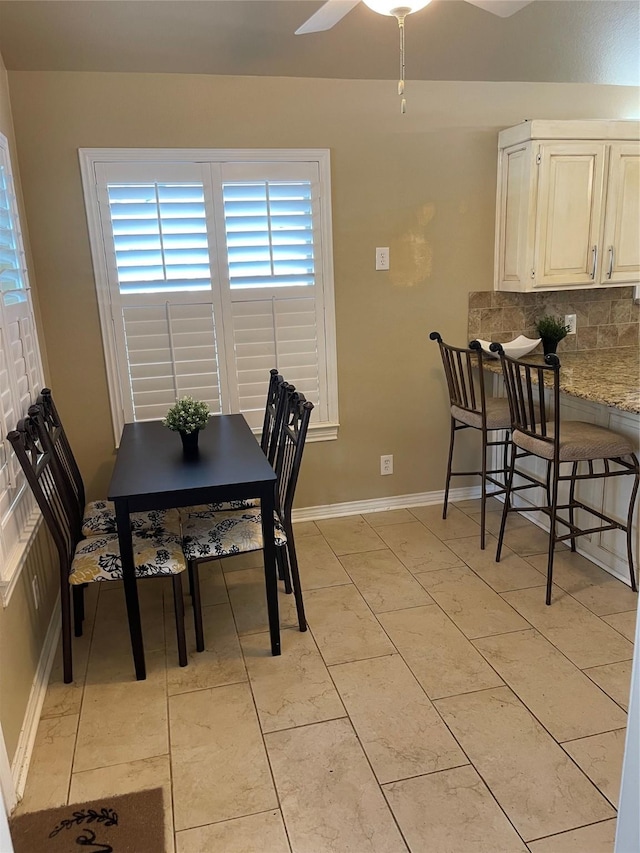 dining room featuring a ceiling fan and baseboards