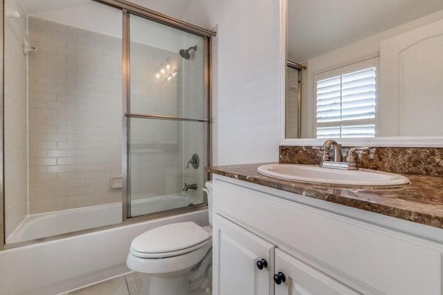 full bathroom with tile patterned floors, combined bath / shower with glass door, toilet, and vanity