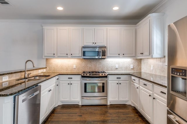 kitchen featuring visible vents, a sink, dark wood-style floors, appliances with stainless steel finishes, and white cabinets