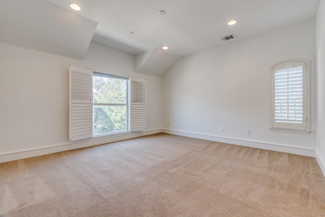 unfurnished room with recessed lighting, visible vents, carpet flooring, and vaulted ceiling