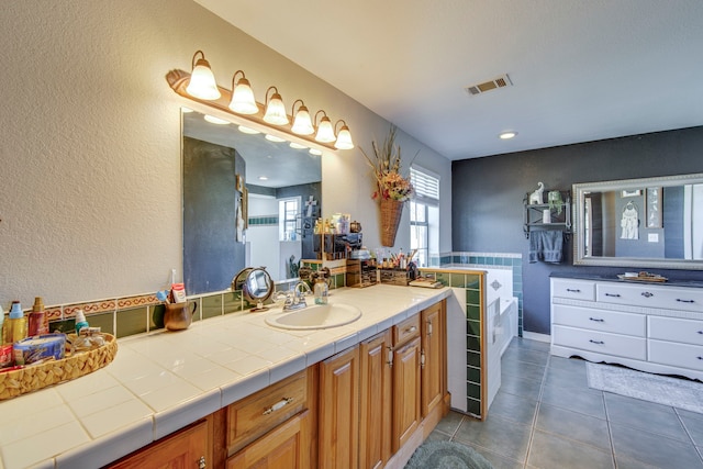 bathroom with visible vents, a garden tub, vanity, and tile patterned flooring