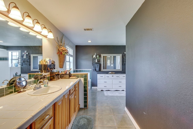 bathroom featuring tile patterned flooring, vanity, visible vents, and baseboards