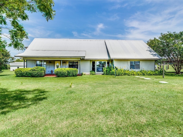 view of front of property featuring a porch, metal roof, and a front lawn