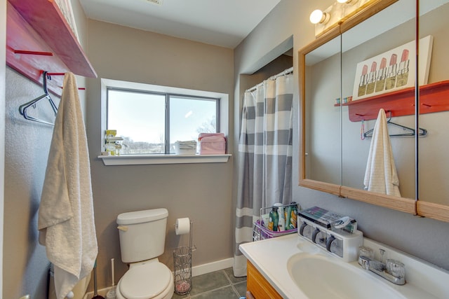 bathroom featuring tile patterned floors, baseboards, toilet, and vanity