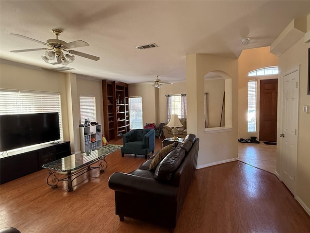 living area with ceiling fan, wood finished floors, visible vents, and baseboards