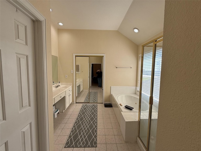 full bath with a sink, tile patterned flooring, double vanity, a bath, and vaulted ceiling