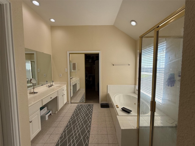 bathroom featuring tile patterned floors, vanity, lofted ceiling, a bath, and a spacious closet