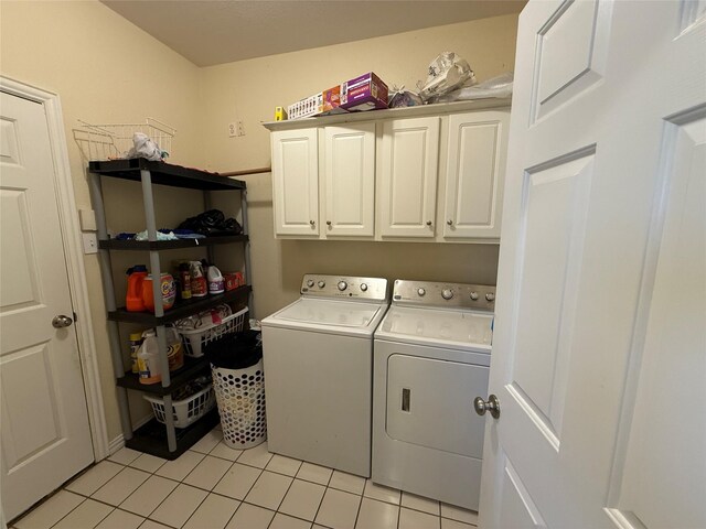 clothes washing area with light tile patterned floors, cabinet space, and washing machine and dryer