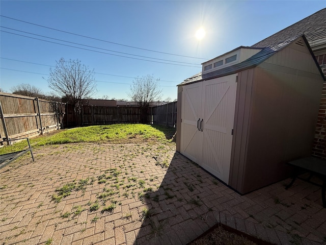 view of yard featuring a patio, an outdoor structure, a storage shed, and a fenced backyard