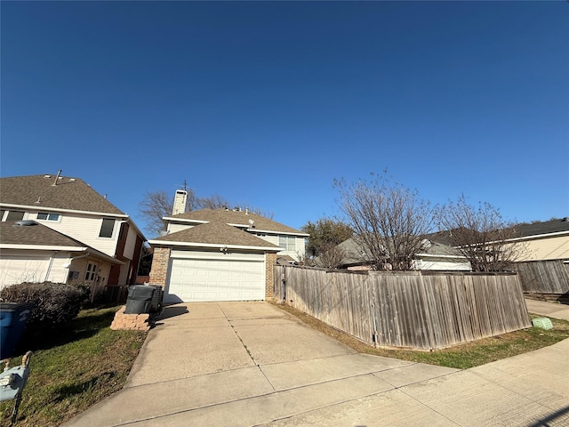 view of home's exterior with driveway, fence, an attached garage, brick siding, and a chimney