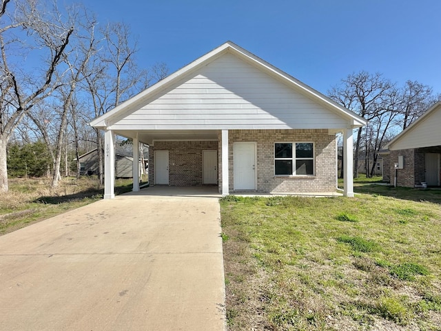 view of front of home featuring brick siding, an attached carport, driveway, and a front lawn