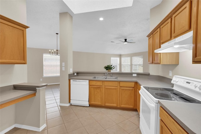 kitchen featuring under cabinet range hood, light tile patterned floors, ceiling fan with notable chandelier, white appliances, and a sink