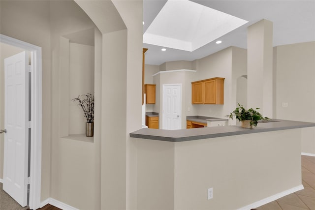 kitchen with light tile patterned floors, recessed lighting, a peninsula, and baseboards