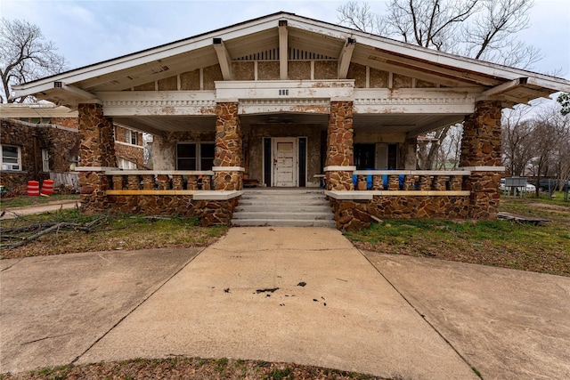 view of front of house with stone siding and a porch