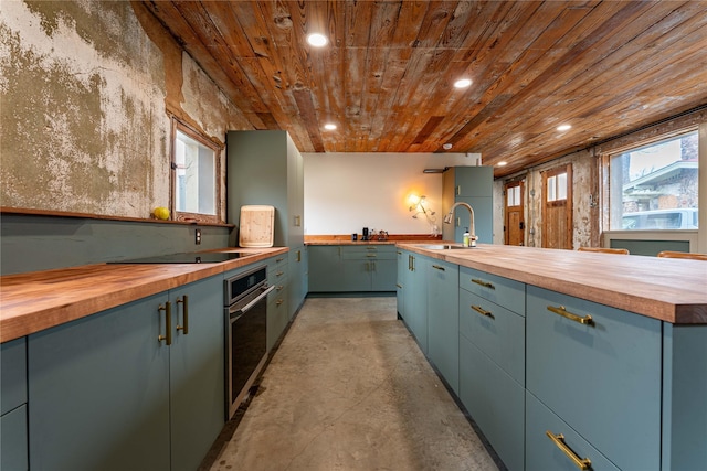 kitchen with concrete floors, oven, wood ceiling, wood counters, and a sink