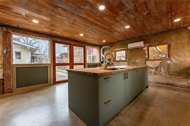 kitchen featuring a sink, finished concrete flooring, a wall mounted air conditioner, wood counters, and a kitchen island with sink