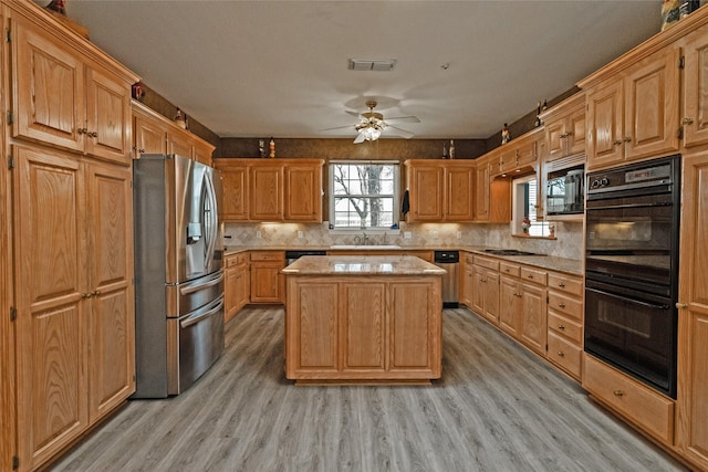 kitchen with backsplash, a kitchen island, light wood-type flooring, stainless steel appliances, and a sink