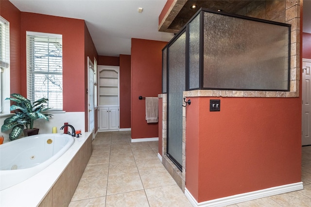 bathroom with a jetted tub, a stall shower, and tile patterned flooring