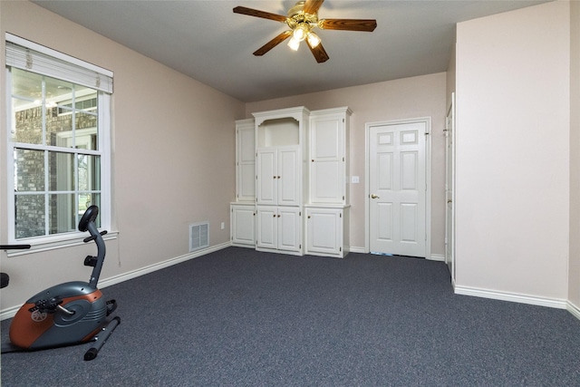 exercise room with baseboards, visible vents, dark colored carpet, and ceiling fan