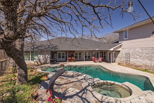 view of pool featuring french doors, a pool with connected hot tub, and a patio