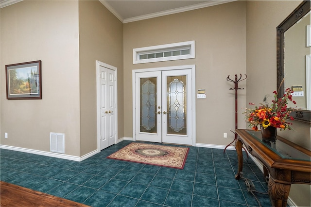 entrance foyer with visible vents, dark tile patterned flooring, ornamental molding, french doors, and baseboards