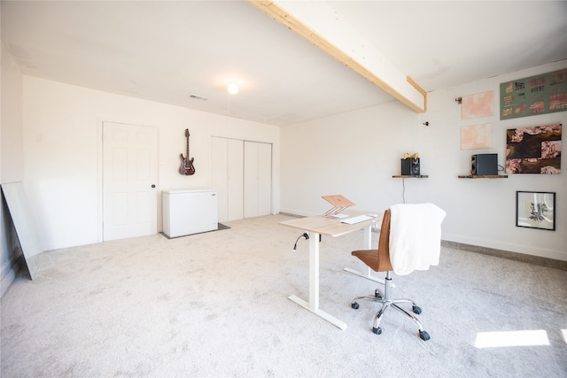 home office with beam ceiling, carpet flooring, and visible vents