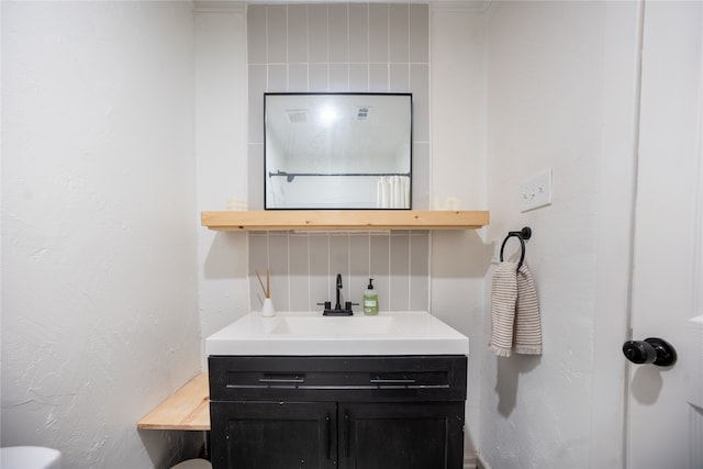 bathroom with vanity and a textured wall