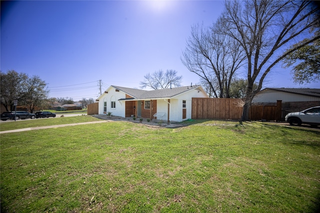 view of front of property featuring a front yard, fence, and brick siding