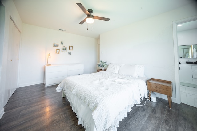 bedroom featuring visible vents, a ceiling fan, dark wood finished floors, connected bathroom, and baseboards