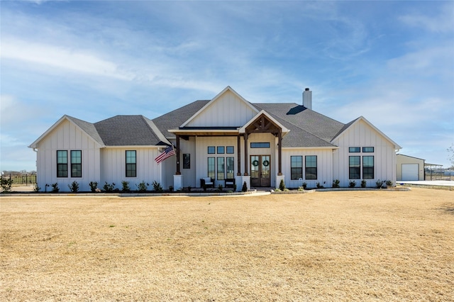 modern inspired farmhouse with a shingled roof, french doors, board and batten siding, and a chimney