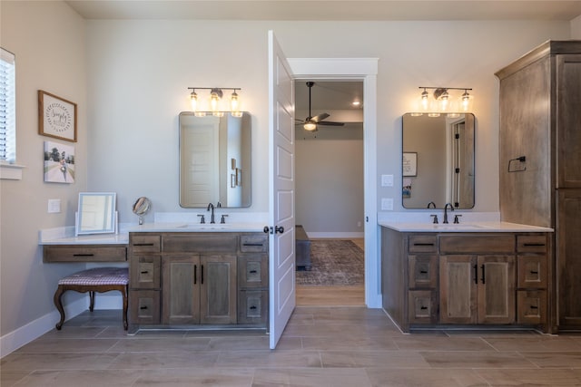 full bath with two vanities, a ceiling fan, and a sink