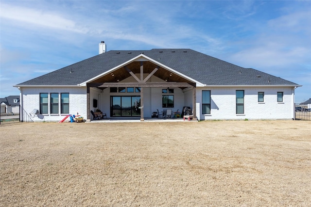 back of property featuring brick siding, a patio area, a chimney, and fence