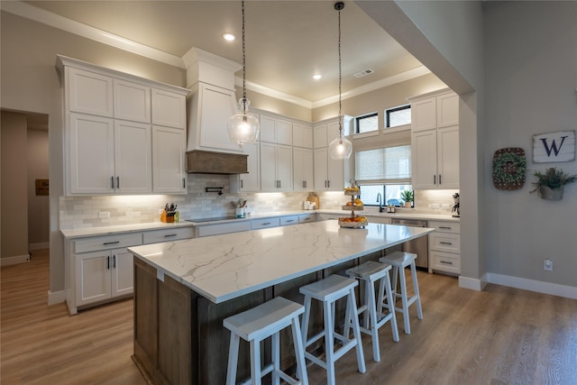 kitchen with baseboards, tasteful backsplash, a kitchen island, and white cabinetry