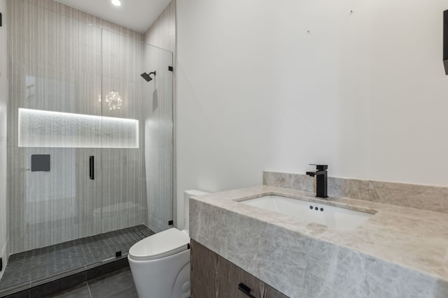 bathroom with tile patterned floors, a shower stall, toilet, and vanity