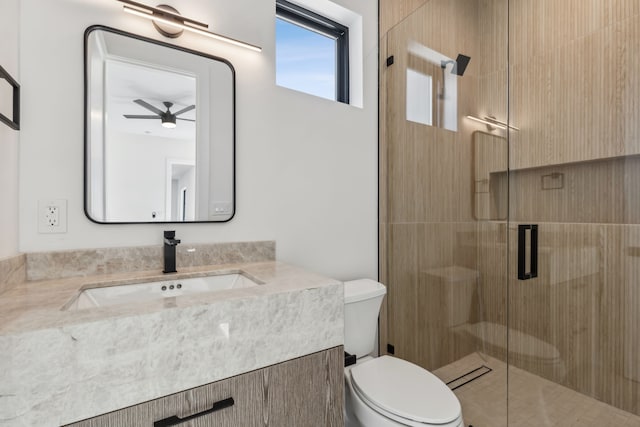 full bathroom featuring vanity, toilet, ceiling fan, and a shower stall